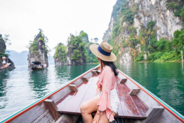 A woman solo backpacking in Khao Sok taking a long-tail boat ride to explore the area