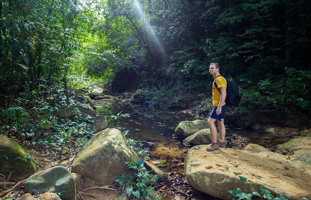 A man trekking through Khao Sok with sturdy shoes and a daypack from his travel checklist