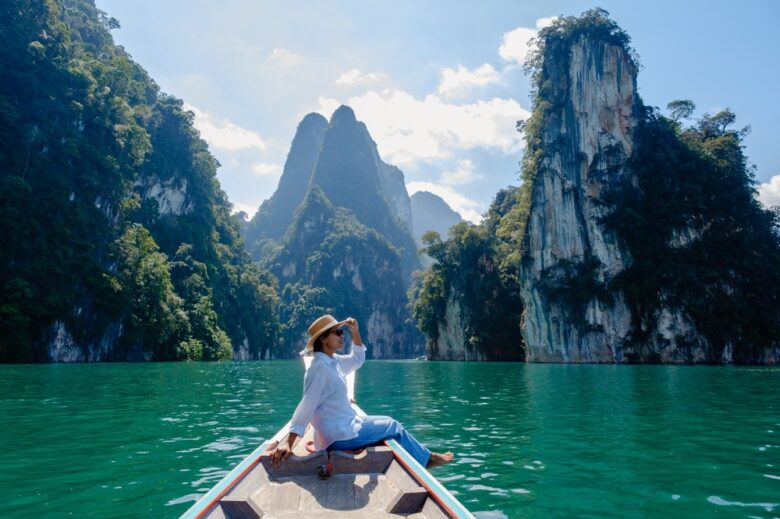 Woman posing at the bow of a long-tail boat on Cheow Lan Lake, a top photo spot in Khao Sok